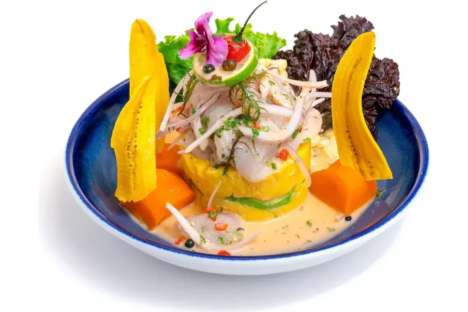 Causa acevichada: causa de papa amarilla rellena de palta, coronada con ceviche y bañada en leche de tigre